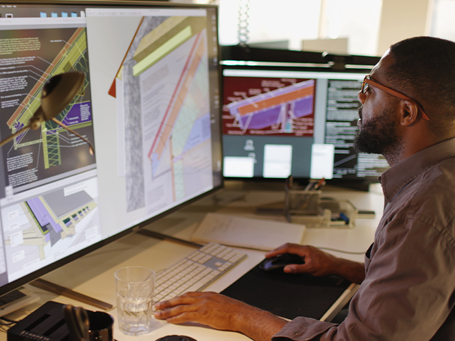 Man sitting in front of a computer with 3D designs