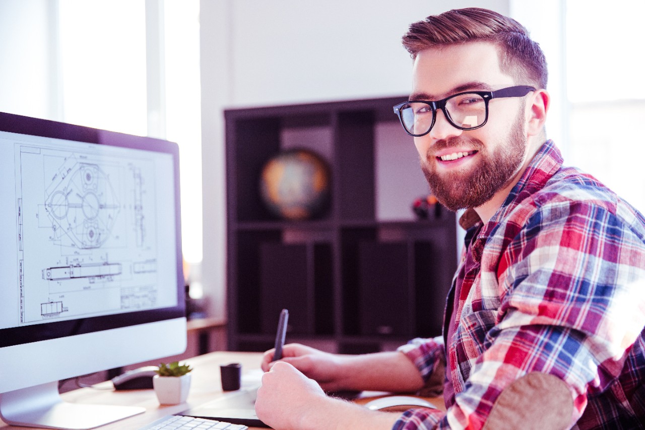 Happy designer drawing blueprint on computer using pen tablet Portrait of happy handsome modern designer drawing blueprint on computer using pen tablet with stylus
