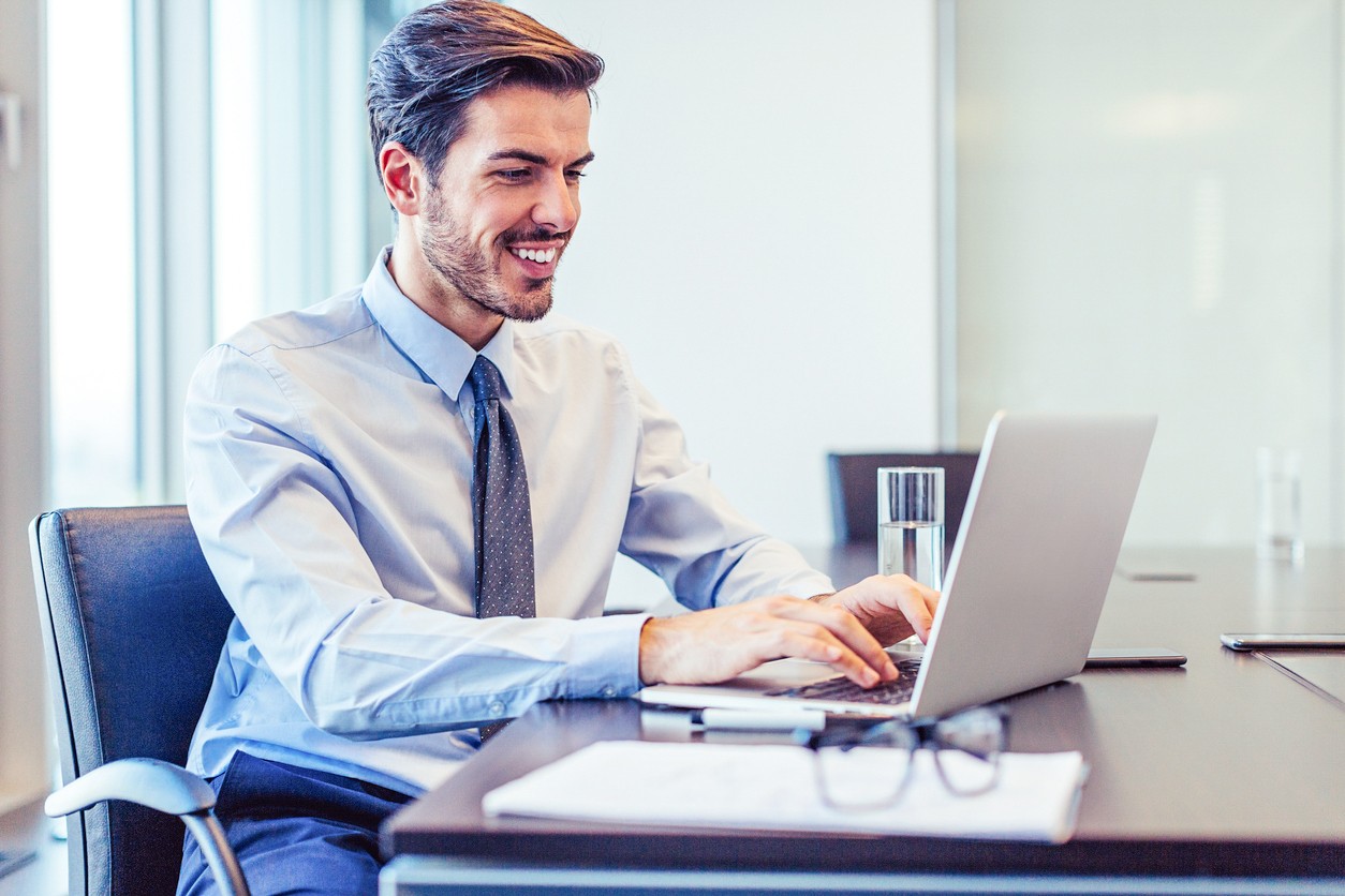 627337484 Smiling businessman warking in his office, with copy space.